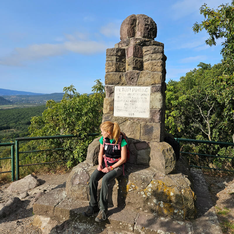 Egy turista ül a Petőfi-pihenőnél a Kő-hegyen.