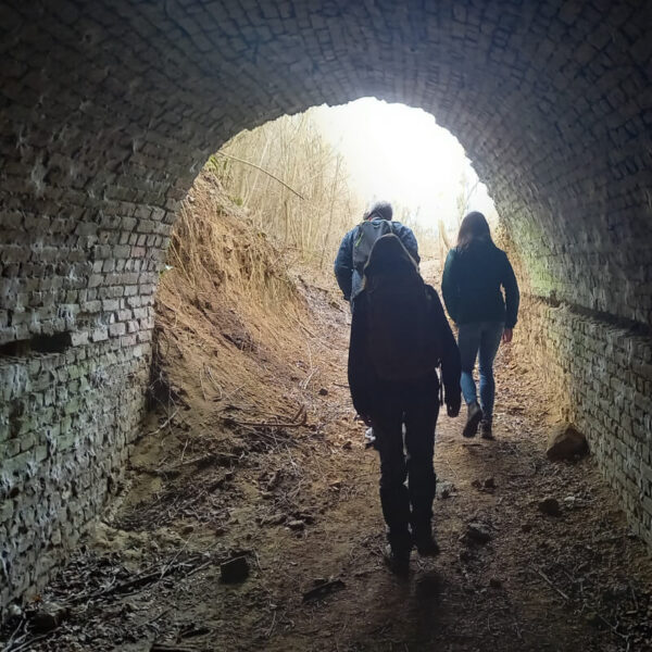 Három turista sétál kifelé egy szénbányász táróból.